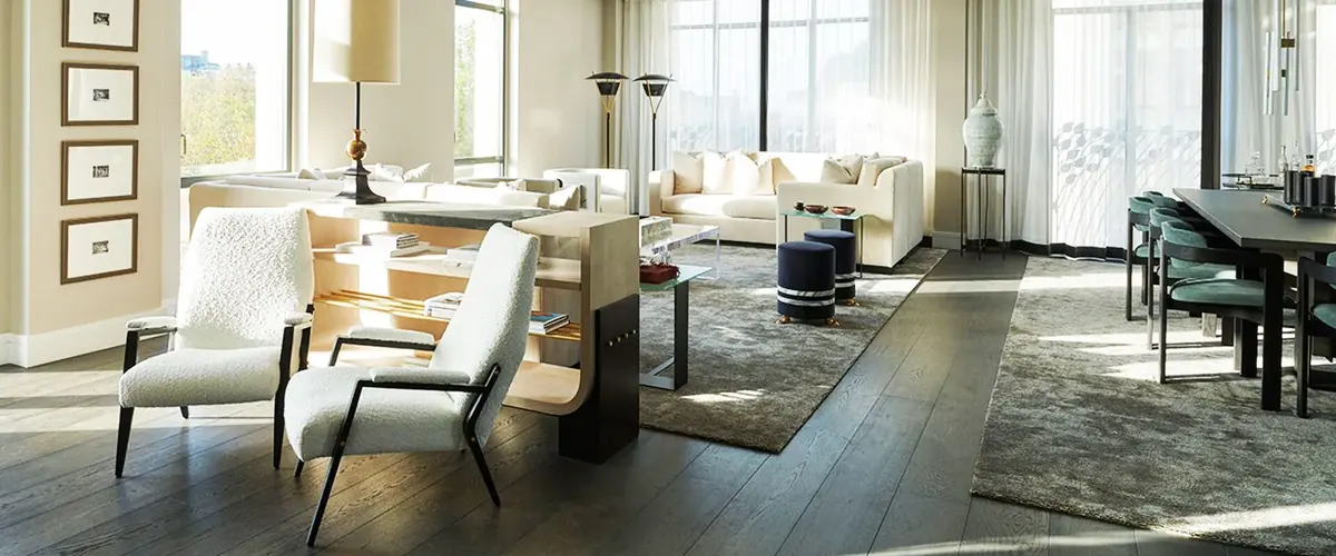 Cream armchairs and sofas in the sunlit living room of Project Thomas, bespoke furniture